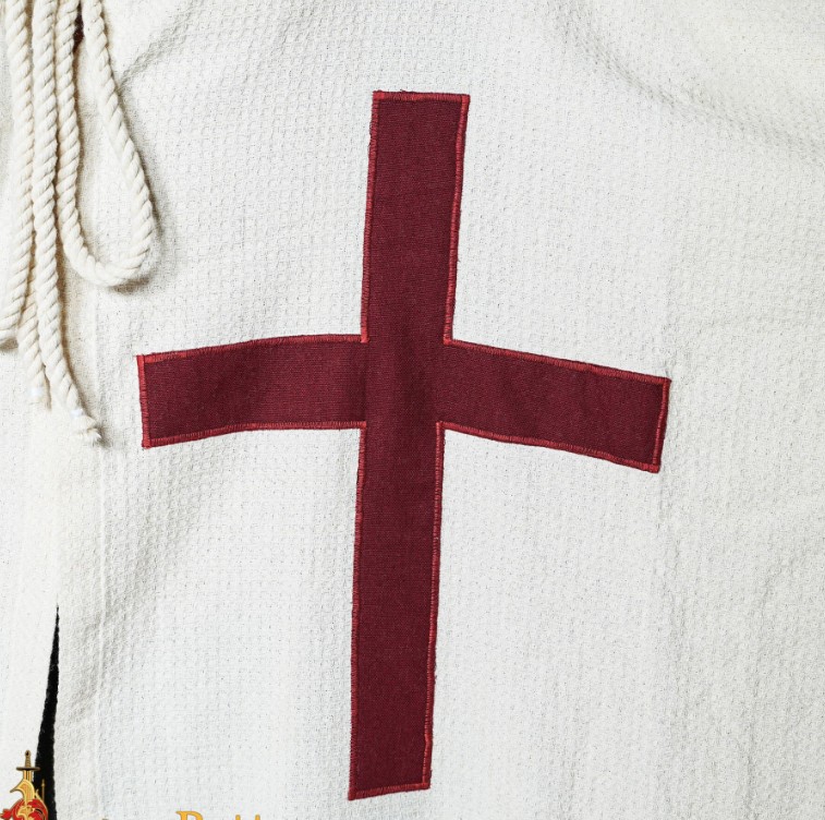 Détail de la croix rouge emblématique cousue sur la poitrine de la cape médiévale
